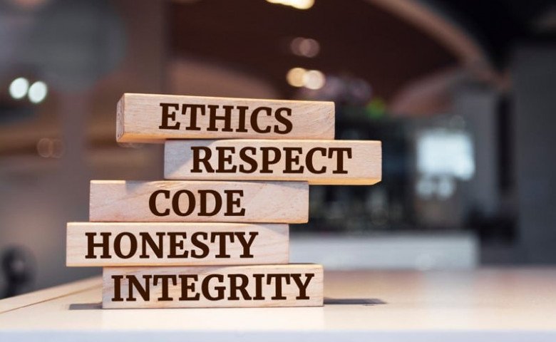 Stack of brown jenga blocks that start with ethics, respect, code, honesty, integrity